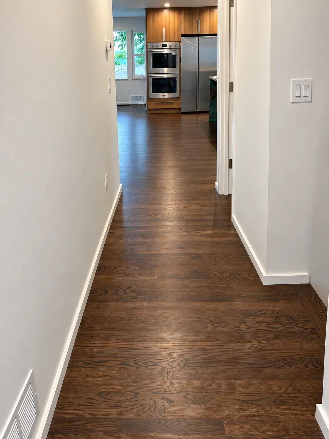 Dark walnut hardwood hallway leading to the kitchen