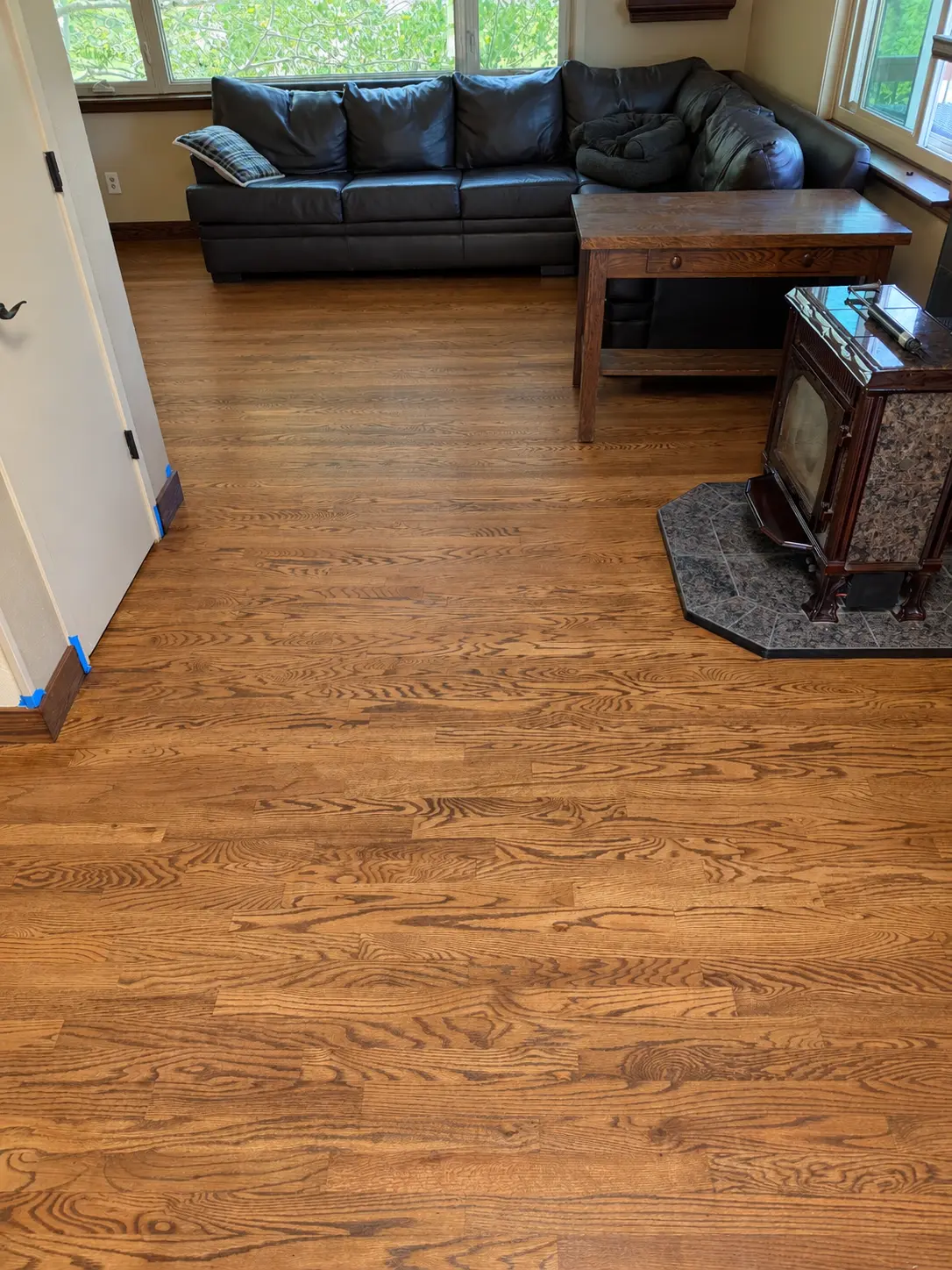Golden oak hardwood floor around a wood-burning fireplace