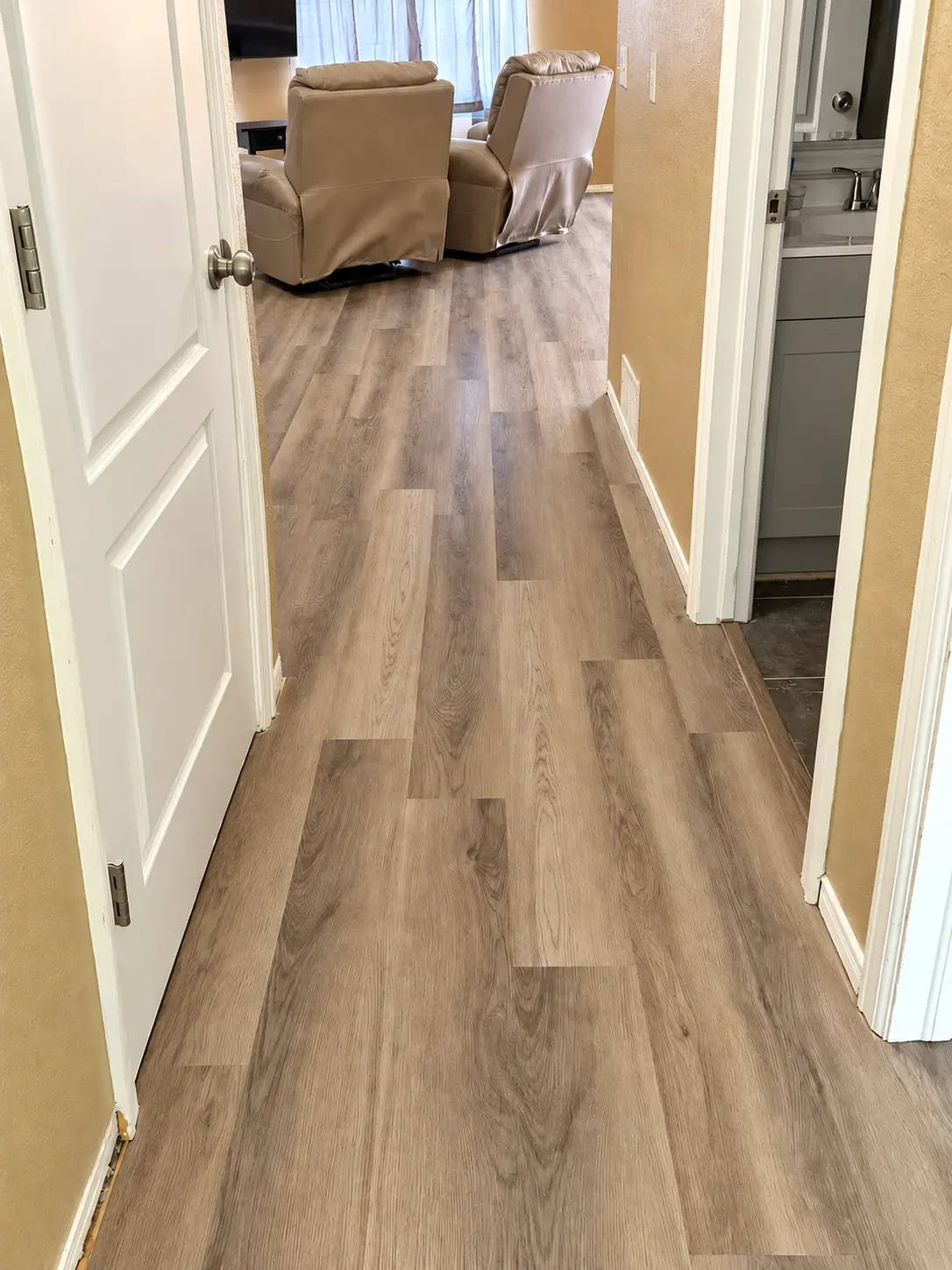 Gray-washed oak luxury vinyl plank through a hallway