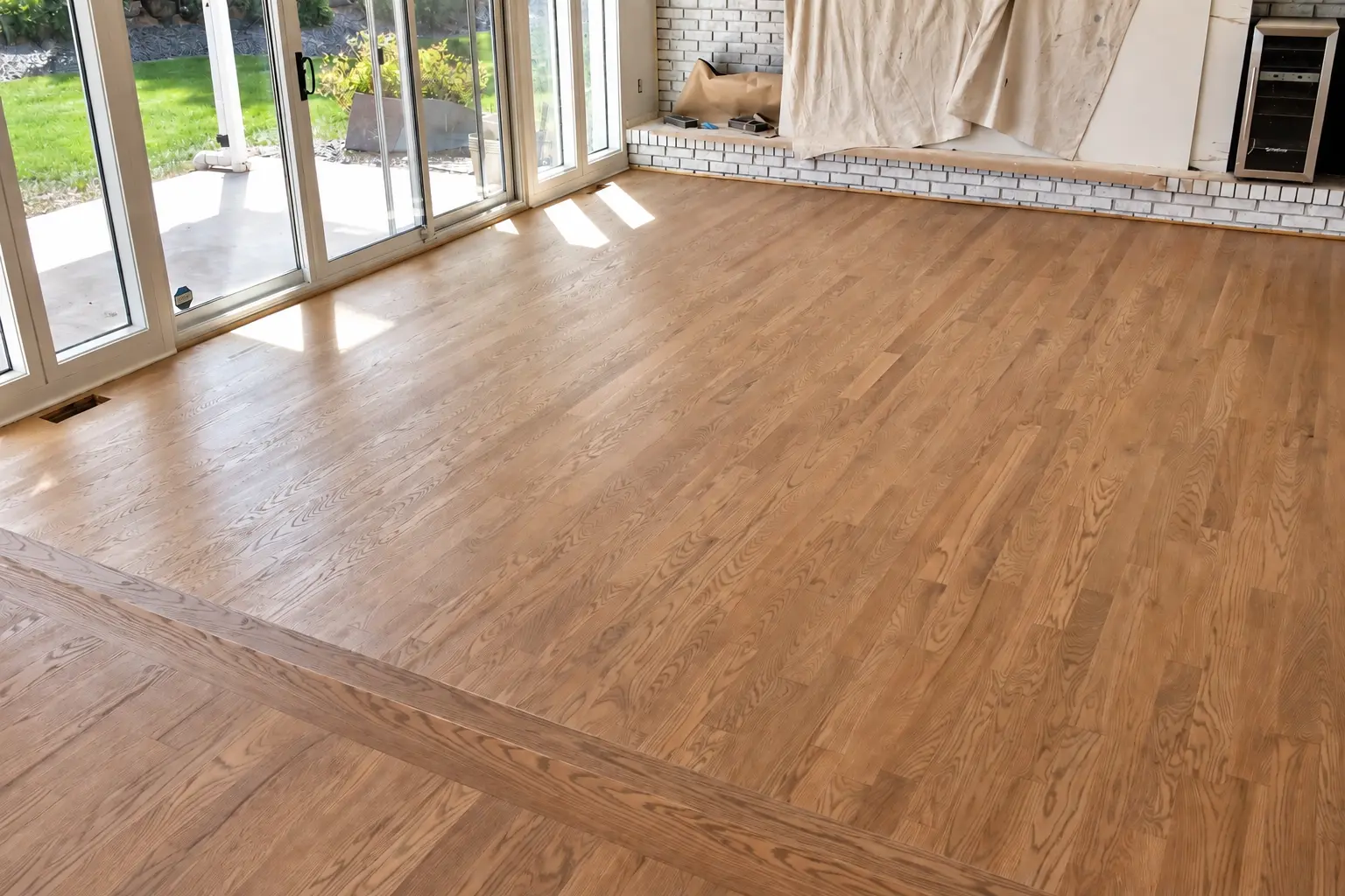 Natural oak hardwood floor beside sliding patio doors