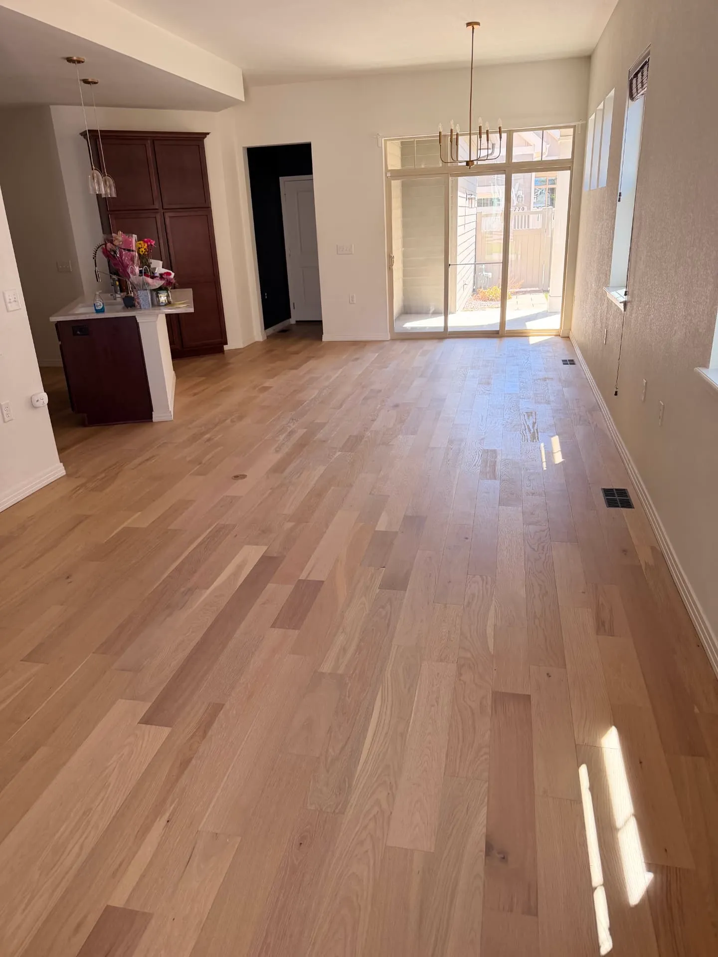 Light natural oak hardwood across an open living room and kitchen