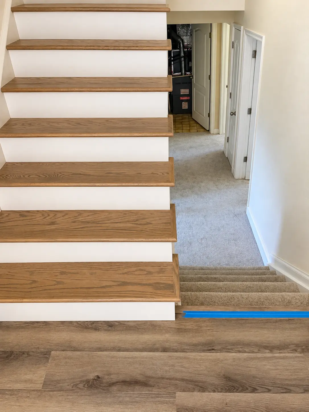 Oak stair treads with white risers meeting a carpeted landing