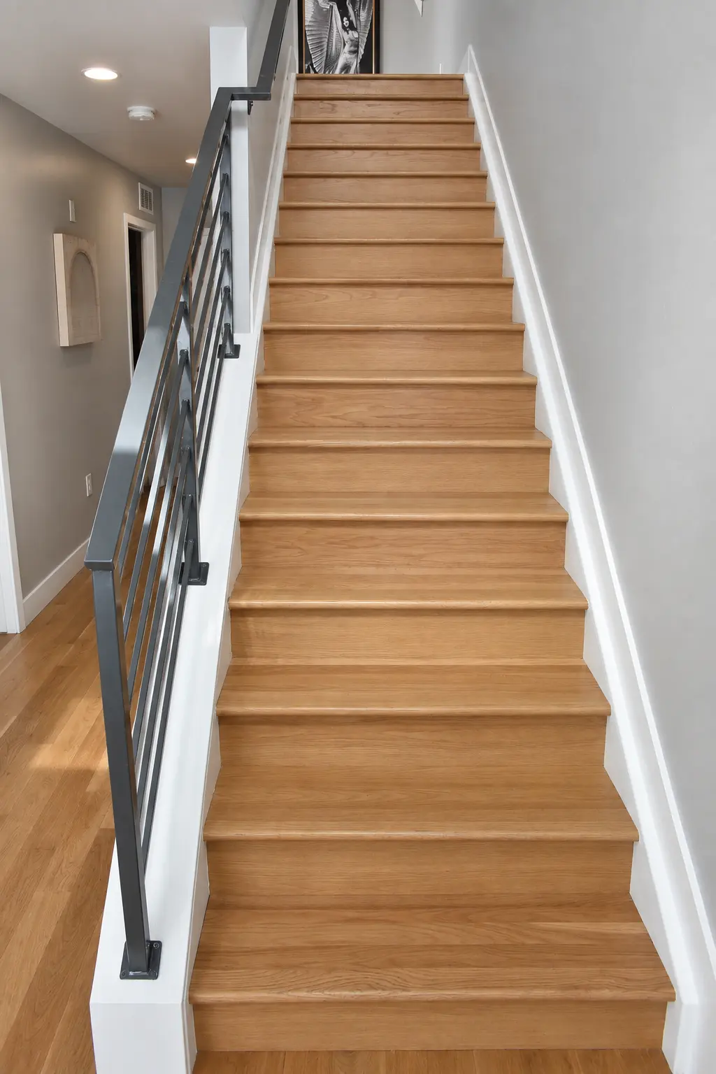 Oak staircase run with a dark metal railing