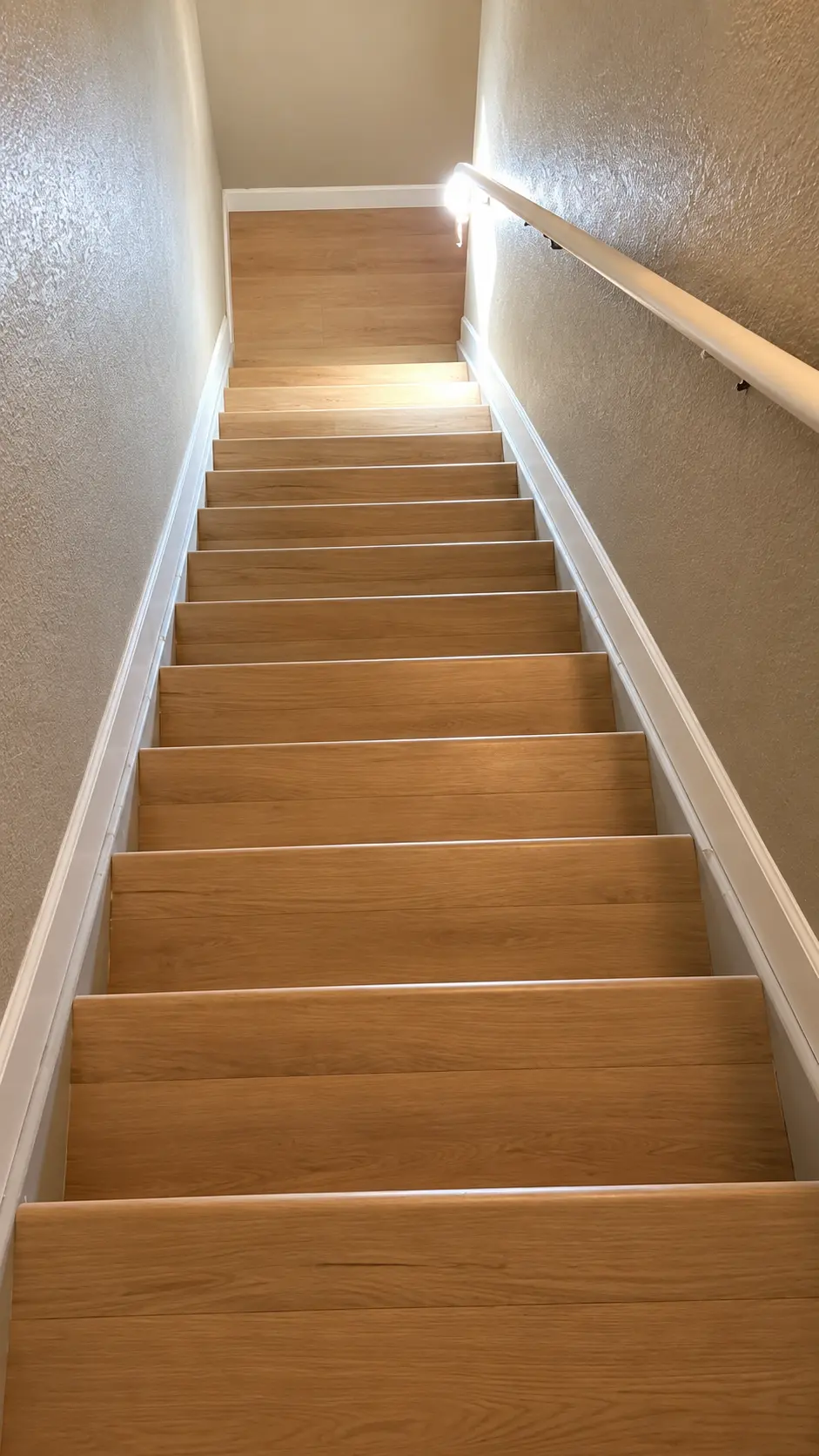 White oak hardwood staircase run with a light handrail